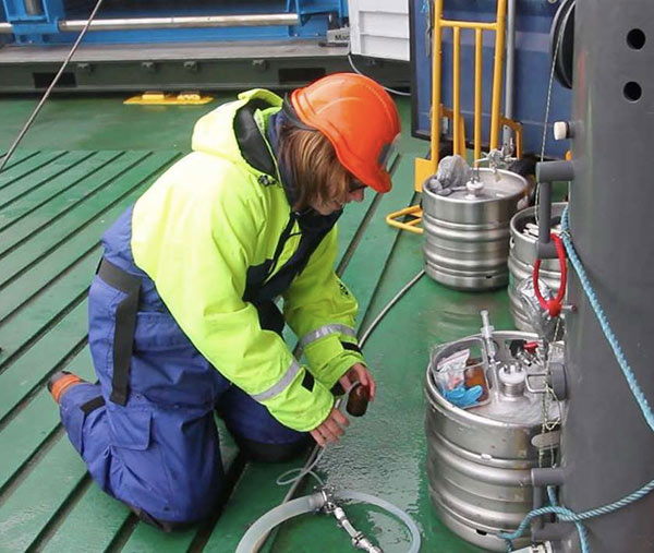 Julia sampling seawater – not beer – from beer kegs.